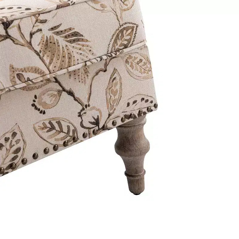 Fauteuil rembourré en bois avec motif floral, accoudoirs à panneaux et dossier en forme de bosse de chameau.
