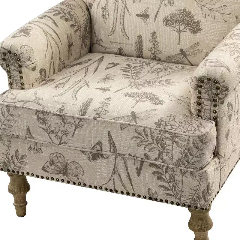 Fauteuil rembourré en bois avec motif floral, accoudoirs à panneaux et dossier en forme de bosse de chameau.