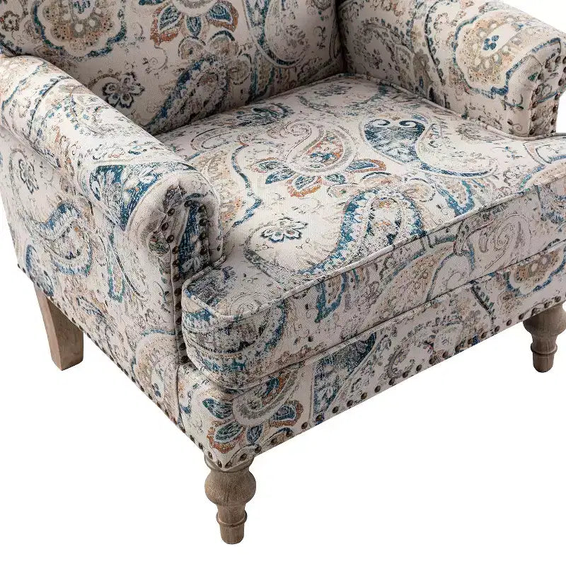Fauteuil rembourré en bois avec motif floral, accoudoirs à panneaux et dossier en forme de bosse de chameau.