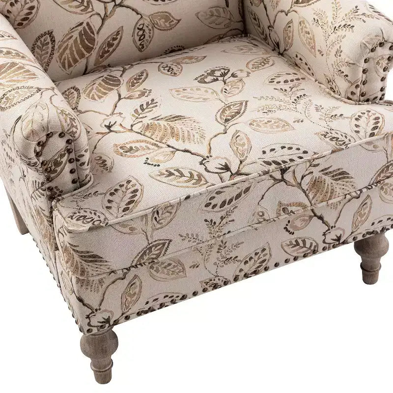 Fauteuil rembourré en bois avec motif floral, accoudoirs à panneaux et dossier en forme de bosse de chameau.